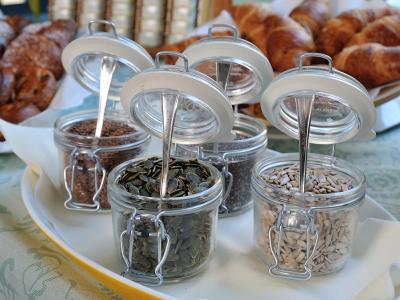 Jars of various seeds with croissants in the background.