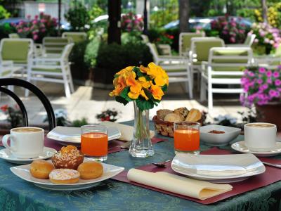 Colazione all'aperto con caffè, succo d'arancia e dolci.