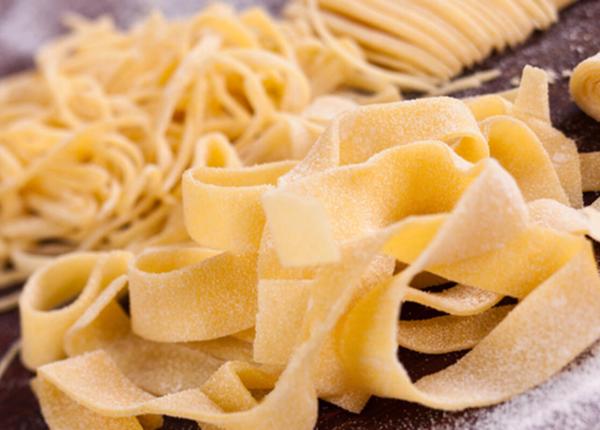 Pâtes fraîches faites à la main sur une table farinée.