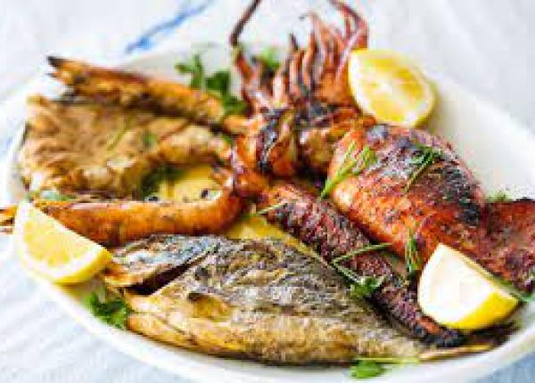 Piatto di pesce grigliato con limone e prezzemolo.