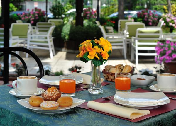 Colazione all'aperto con caffè, succo d'arancia e dolci.