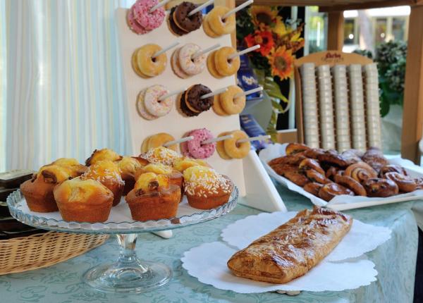 Buffet di dolci con muffin, ciambelle e pasticcini.